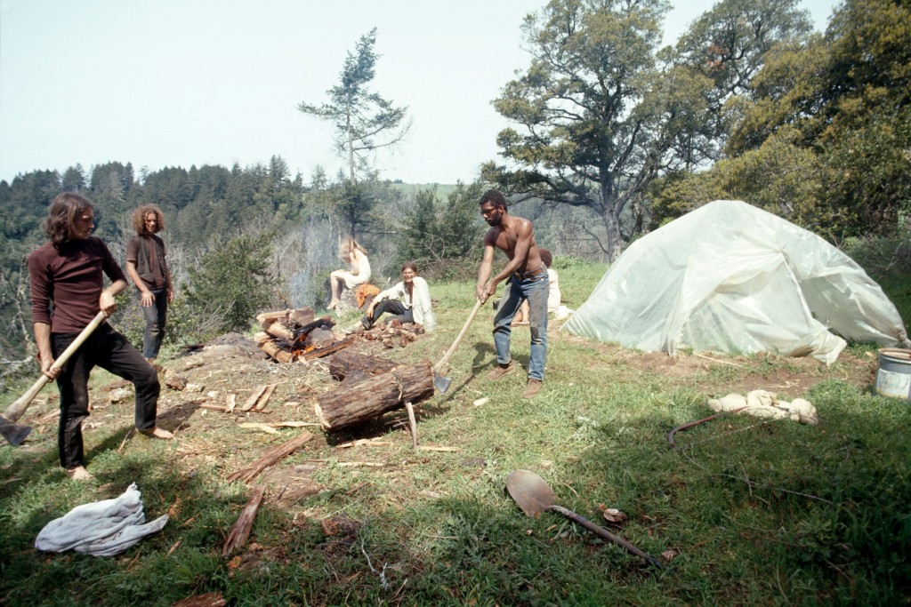 Color photograph of people working outside next to a plastic tent.