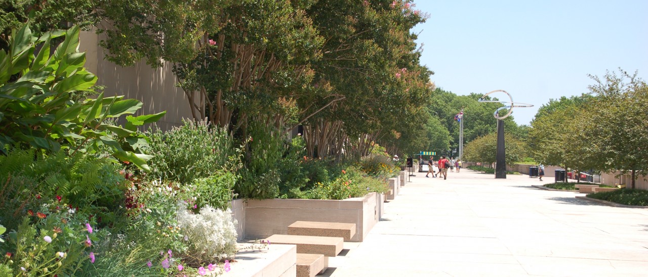 Flowers fill raised stone planting beds along the outside of the National Museum of American History