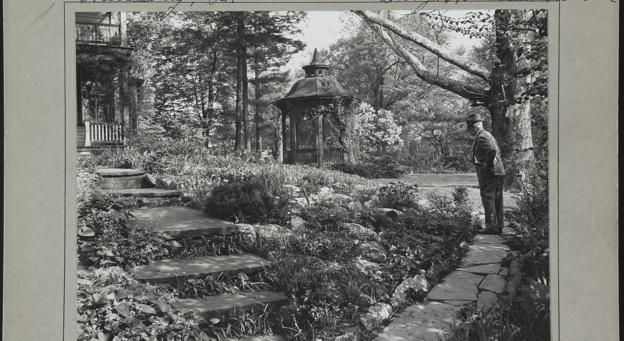 Vintage photo of J. Horace McFarland looking over a garden with pagoda in background