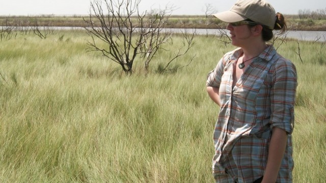 Woman standing in field of grass