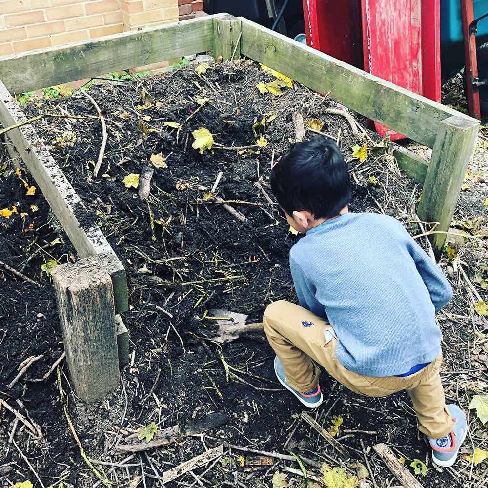 Child shoveling compost