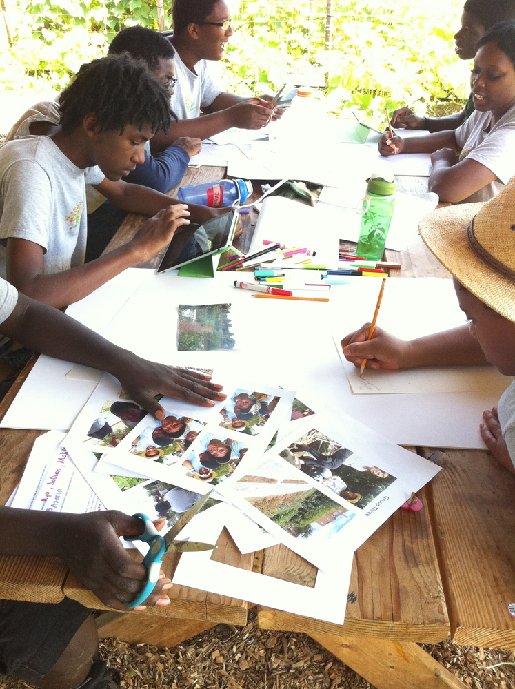 Kids at picnic table cutting out pictures and writing on them