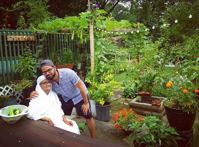 Older woman and young man at picnic bench next to potted plants and flowers