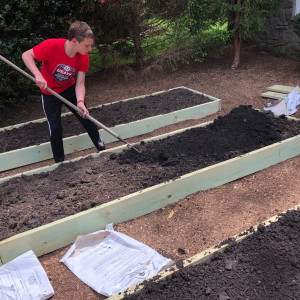 Ivan rakes the garden beds at Ivan's Garden.