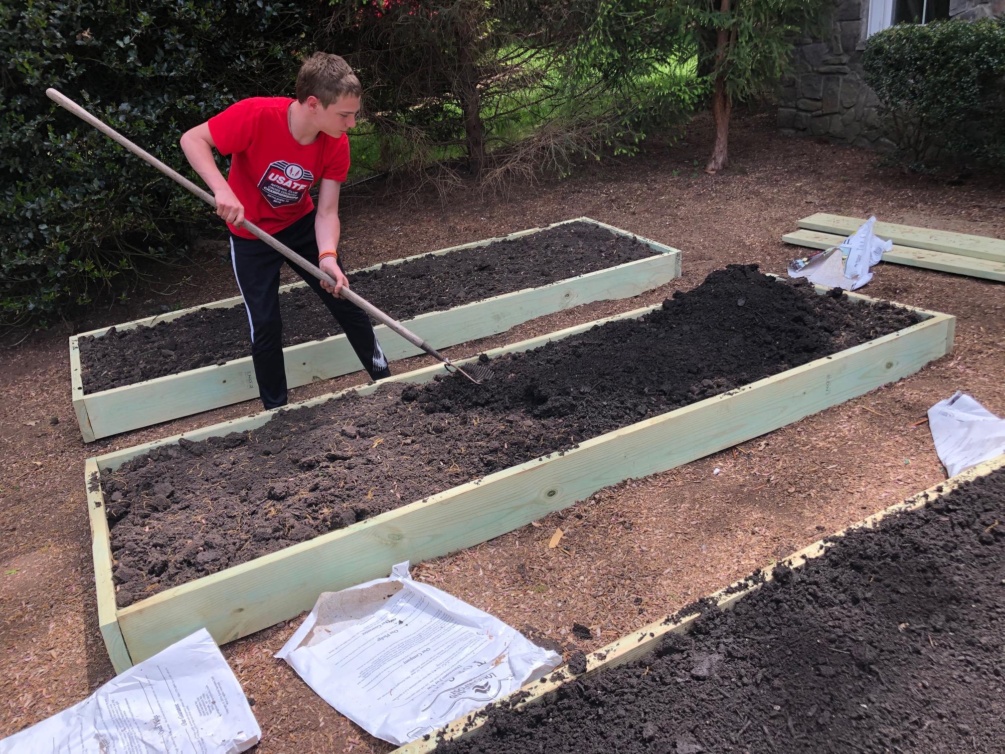 Ivan rakes the garden beds at Ivan's Garden.