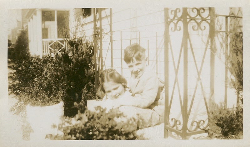 Posing outside of the sunporch at her family's home in New Orleans. Bridal wreath blooming in corner