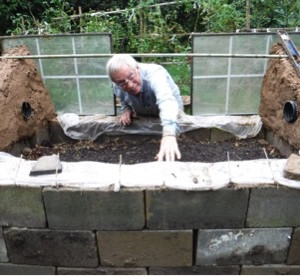 The cold frame is built of cbb, cement blocks, a glass cover, and other materials., Ed at work on the handicap-accessible cold frame.