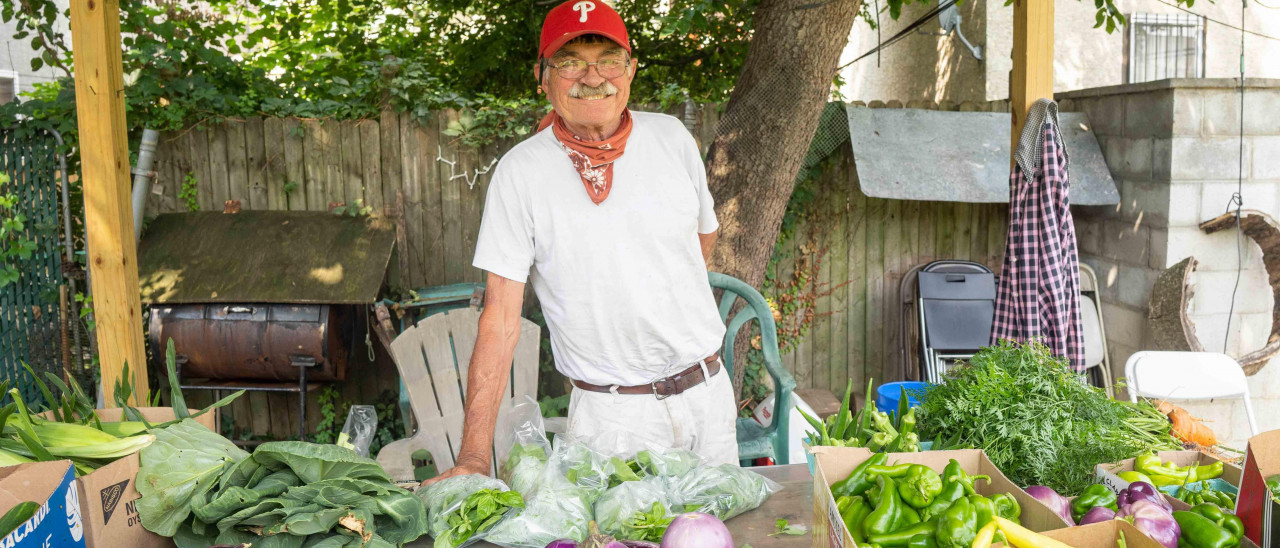 2022 photo taken by Milton Lindsay of garden founder John Lindsay at the farmstand for the Wiota Street Community Garden