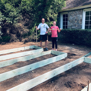 Ivan and his dad pose by the raised bed frames at Ivan's Garden.