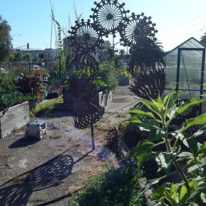 The three legs of the large billboard located in Big Daddy's Complete Rejuvenating Community Garden are seen next to "Peace Towers," one of the sculptures by Vickie Jo Sowell that are located in the garden.