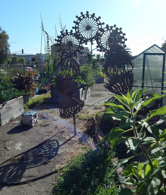 The three legs of the large billboard located in Big Daddy's Complete Rejuvenating Community Garden are seen next to "Peace Towers," one of the sculptures by Vickie Jo Sowell that are located in the garden.