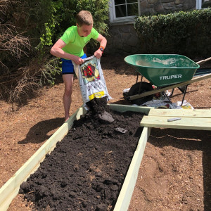 Ivan fills his garden beds with soil at Ivan's Garden.