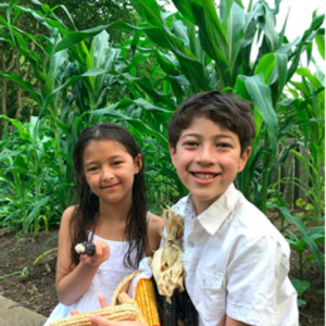 Popcorn Summer: Family Gardening with Indigenous Seeds. Children with corn cobs from their Popcorn Summer Garden.